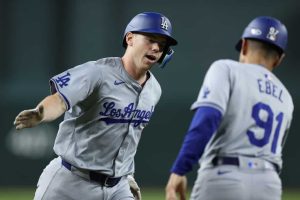 Will Smith #16 of the Los Angeles Dodgers high fives third base coach Dino Ebel #91 after hitting a solo home run against the Arizona Diamondbacks during the sixth inning of the MLB game at Chase Field on April 29, 2024 in Phoenix, Arizona.