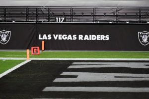 Las Vegas Raiders logos are shown on a wall before a game between the Raiders and the Los Angeles Chargers at Allegiant Stadium on December 17, 2020 in Las Vegas, Nevada. The Chargers defeated the Raiders 30-27 in overtime.