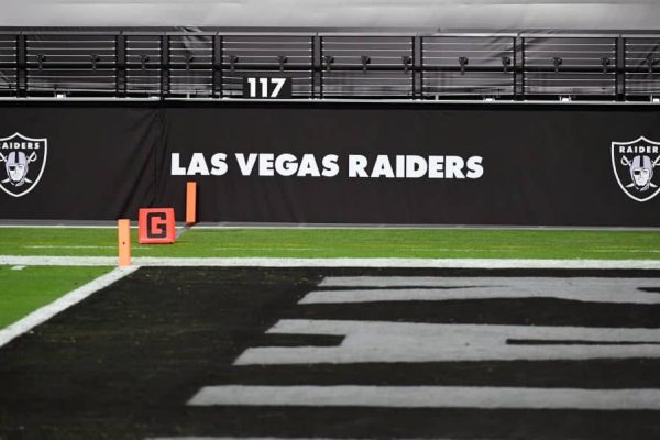 Las Vegas Raiders logos are shown on a wall before a game between the Raiders and the Los Angeles Chargers at Allegiant Stadium on December 17, 2020 in Las Vegas, Nevada. The Chargers defeated the Raiders 30-27 in overtime.