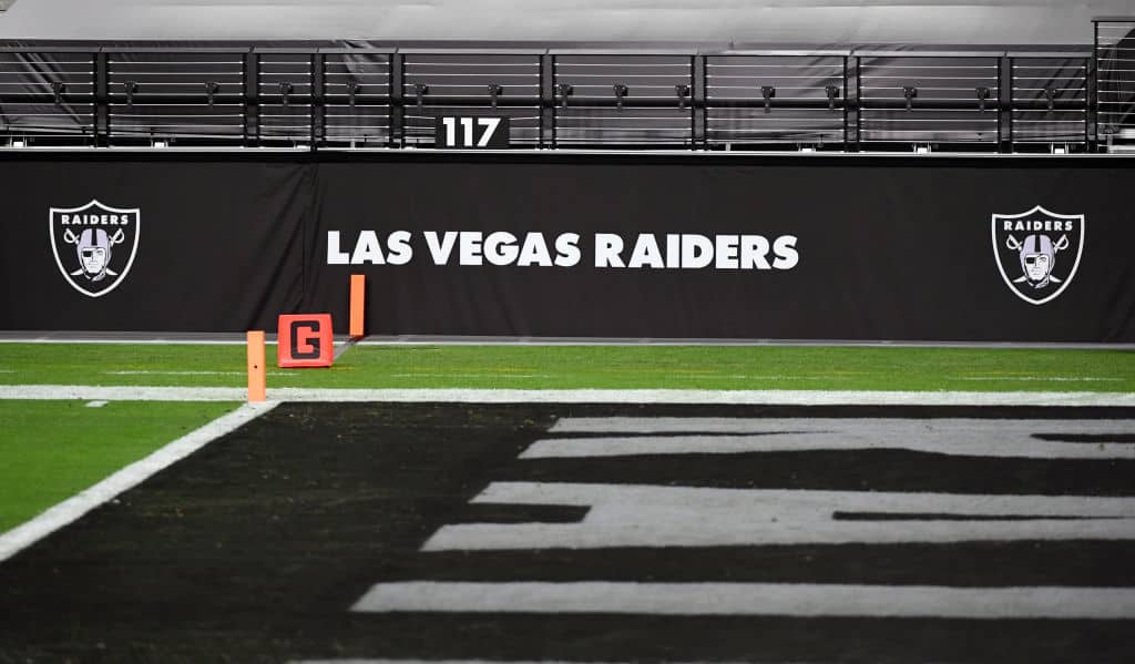 Las Vegas Raiders logos are shown on a wall before a game between the Raiders and the Los Angeles Chargers at Allegiant Stadium on December 17, 2020 in Las Vegas, Nevada. The Chargers defeated the Raiders 30-27 in overtime.