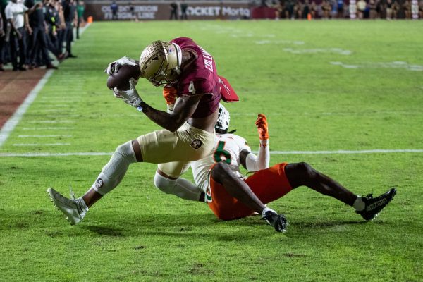Florida State Seminoles wide receiver Keon Coleman (4) catches a pass from Florida State Seminoles quarterback Jordan Travis (13) for a touchdown. The Florida State Seminoles defeated the Miami Hurricanes 27-20 on Saturday, Nov. 11, 2023.