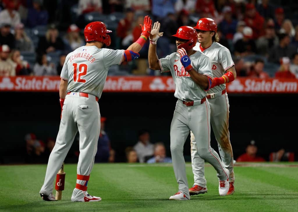 Johan Rojas #18 of the Philadelphia Phillies is congartulated by Kyle Schwarber #12 of the Philadelphia Phillies after hitting a two run home run against the Los Angeles Angels during the ninth inning at Angel Stadium of Anaheim on April 30, 2024 in Anaheim, California.