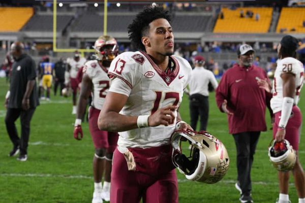 Jordan Travis #13 of the Florida State Seminoles runs off the field following a 24-7 win over the Pittsburgh Panthers during the game at Acrisure Stadium on November 4, 2023 in Pittsburgh, Pennsylvania.