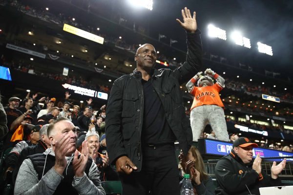 Former NBA player Chris Mullin (L) and former San Francisco Giants player Barry Bonds waves to the crowd during the fifth inning of Game 1 of the National League Division Series against the Los Angeles Dodgers at Oracle Park on October 08, 2021 in San Francisco, California.