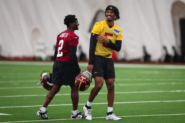 Mike Sainristil #2 and Jayden Daniels #5 of the Washington Commanders laugh together during Washington Commanders Rookie Minicamp at OrthoVirginia Training Center on May 10, 2024 in Ashburn, Virginia.
