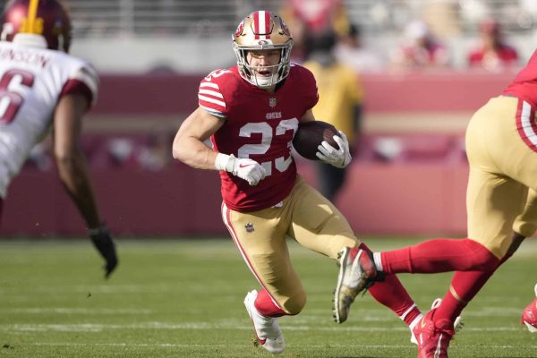 Christian McCaffrey #23 of the San Francisco 49ers carries the ball against the Washington Commanders during the first half of the game at Levi