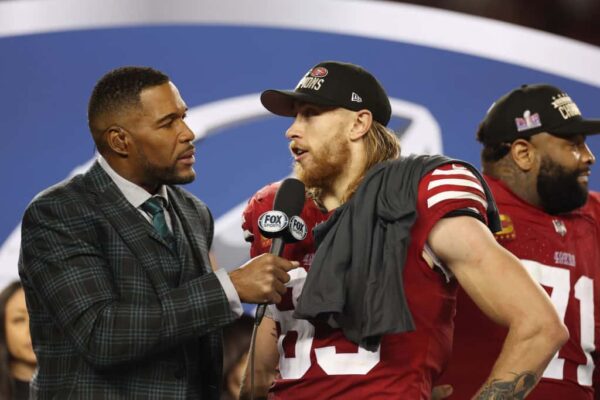 George Kittle #85 of the San Francisco 49ers is interviewed by NFL commentator and former NFL player Michael Strahan after defeating the Detroit Lions 34-31 in the NFC Championship Game at Levi
