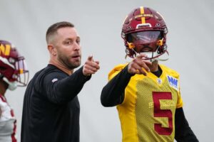 Offensive coordinator Kliff Kingsbury of the Washington Commanders instructs Jayden Daniels #5 during Washington Commanders Rookie Minicamp at OrthoVirginia Training Center on May 10, 2024 in Ashburn, Virginia.