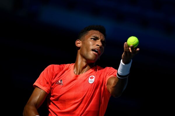Félix Auger-Aliassime tosses the ball to serve.
