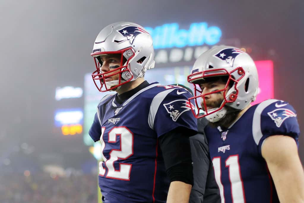 Tom Brady #12 of the New England Patriots and Julian Edelman #11 look on after Edelman scored a touchdown in the second quarter of the AFC Wild Card Playoff game at Gillette Stadium on January 04, 2020 in Foxborough, Massachusetts.