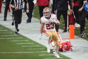 San Francisco 49ers running back Christian McCaffrey (23) runs with the ball against Kansas City Chiefs safety Mike Edwards (21) during overtime of Super Bowl LVIII at Allegiant Stadium. What's the latest Christian McCaffrey injury update? Mandatory Credit: Joe Camporeale-Imagn Images