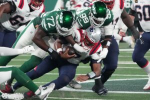 New England Patriots quarterback Jacoby Brissett (7) sacked by New York Jets defensive end Micheal Clemons (72) and defensive end Will McDonald IV (99) in the 1st half at MetLife Stadium. Mandatory Credit: Robert Deutsch-Imagn Images