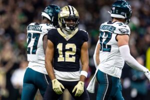 Sep 22, 2024; New Orleans, Louisiana, USA; New Orleans Saints wide receiver Chris Olave (12) reacts to making a first down reception against Philadelphia Eagles safety Reed Blankenship (32) during the first half at Caesars Superdome. Mandatory Credit: Stephen Lew-Imagn Images