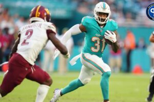 Miami Dolphins running back Raheem Mostert (31) gets short gain as Washington Commanders cornerback Mike Sainristil (2) closes in during the first quarter at Hard Rock Stadium. Mandatory Credit: Jim Rassol-Imagn Images