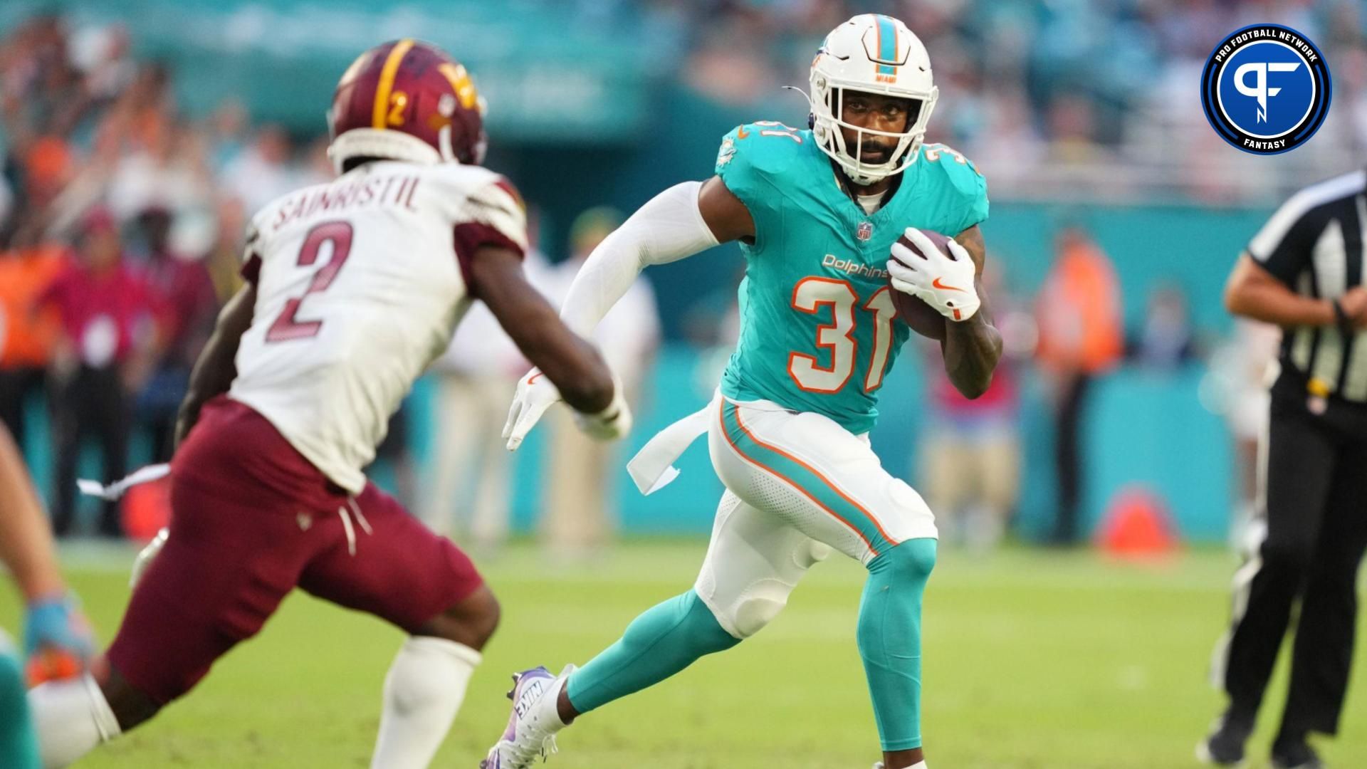 Miami Dolphins running back Raheem Mostert (31) gets short gain as Washington Commanders cornerback Mike Sainristil (2) closes in during the first quarter at Hard Rock Stadium. Mandatory Credit: Jim Rassol-Imagn Images
