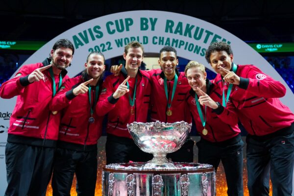 Frank Dancevic, Alexis Galarneau, Vasek Pospisil, Felix Auger-Aliassime, Denis Shapovalov, and Gabriel Diallo stand behind the Davis Cup trophy. The same five players will represent Canada at hte upcoming group stage in Manchester.