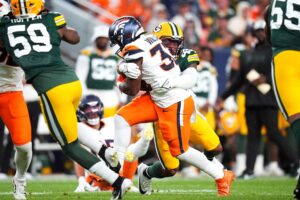 Aug 18, 2024; Denver, Colorado, USA; Green Bay Packers linebacker Eric Wilson (45) tackles Denver Broncos running back Javonte Williams (33) in the first quarter at Empower Field at Mile High. Mandatory Credit: Ron Chenoy-USA TODAY Sports