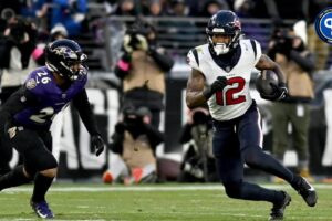 Houston Texans wide receiver Nico Collins (12) runs the ball against Baltimore Ravens safety Geno Stone (26) during the first quarter of a 2024 AFC divisional round game at M&T Bank Stadium.