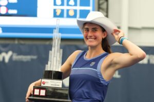 Rebecca Marino tips her cowboy hat while holding her Calgary trophy. She and Kayla Cross were both winners at the ITF event.