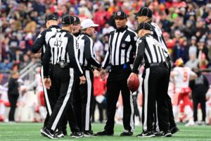 Dec 17, 2023; Foxborough, Massachusetts, USA; NFL referee Shawn Hochuli (83) huddles with his crew during a timeout on the field during the first half of a game between the New England Patriots and the Kansas City Chiefs at Gillette Stadium. Mandatory Credit: Eric Canha-USA TODAY Sports