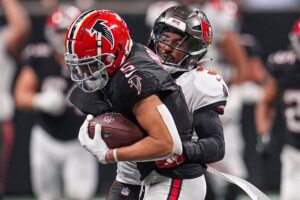 Oct 3, 2024; Atlanta, Georgia, USA; Atlanta Falcons wide receiver Drake London (5) is tackled by Tampa Bay Buccaneers safety Jordan Whitehead (3) after a catch at Mercedes-Benz Stadium. Mandatory Credit: Dale Zanine-Imagn Images