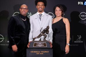 LSU Tigers QB Jayden Daniels poses with his parents after winning the Heisman Trophy.