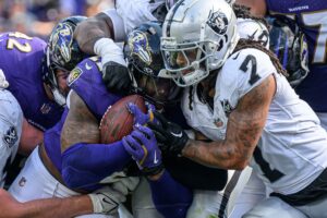 Sep 15, 2024; Baltimore, Maryland, USA; Baltimore Ravens running back Derrick Henry (22) runs for a touchdown while being tackled by Las Vegas Raiders safety Tre'von Moehrig (7) during the second half at M&T Bank Stadium. Mandatory Credit: Reggie Hildred-Imagn Images