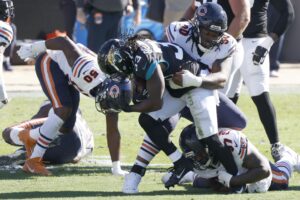 Dec 27, 2020; Jacksonville, Florida, USA; Chicago Bears linebacker Barkevious Mingo (50) and nose tackle John Jenkins (top) and defensive end Mario Edwards Jr. (97) combine to stop Jacksonville Jaguars running back Dare Ogunbowale (33) during the second quarter at TIAA Bank Field. Mandatory Credit: Reinhold Matay-USA TODAY Sports
