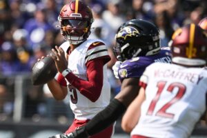 Oct 13, 2024; Baltimore, Maryland, USA; Washington Commanders quarterback Jayden Daniels (5) loos to throws during the first quarter against the Baltimore Ravens at M&T Bank Stadium. Mandatory Credit: Tommy Gilligan-Imagn Images